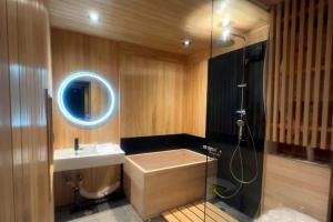 a bathroom with a tub and a sink and a shower at Hokkaido Zen Cabin in Bibai +8 photos