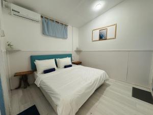 a bedroom with a white bed with a blue headboard at Thulusdhoo Garden Villa in Thulusdhoo