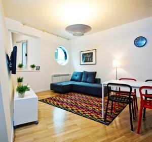 a living room with a blue couch and a table at Irundo Downtown Apartments in Zagreb