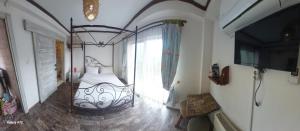 a bedroom with a bed and a tv in a room at AKİDE BUTİK PANSİYON in Mudanya