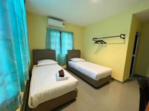 a bedroom with two beds and a window at Kemas Homestay in Johor Bahru