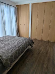 a bedroom with a bed and wooden floors and cabinets at T&T Fujiyama MC2 in Iiyama