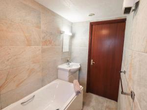 a bathroom with a tub and a toilet and a sink at Ghyll Bank Bungalow in Staveley