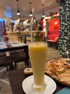 a glass of orange juice on a table with a slice of pizza at Datoni Italian Restaurant in Tabigue +8 photos