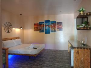 a bedroom with a bed and paintings on the wall at Datoni Italian Restaurant in Tabigue