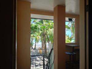 a room with a balcony with a view of the beach at Datoni Italian Restaurant in Tabigue
