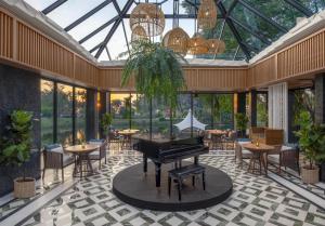 a conservatory with a piano and tables and chairs at Banyan Tree Phuket in Bang Tao Beach