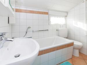 Baño blanco con lavabo y aseo en Holiday Home in Mielinghausen with Garden Terrace, en Reiste