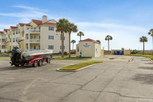 a car parked in a parking lot in front of a building at Island Palms - 2 min walk to the Beach in Corpus Christi
