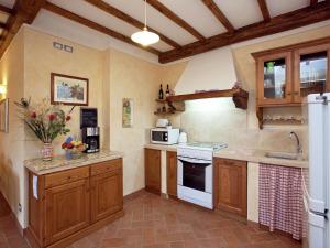 ルチニャーノにあるAmazing apartment in Lucignano with private terrace and close to villageの大きなキッチン(木製キャビネット、白い電化製品付)