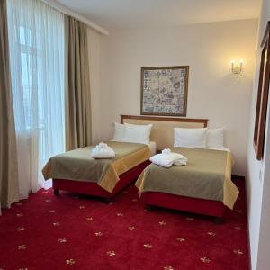 a hotel room with two beds and a window at Atyrau Dastan Hotel in Atyrau +22 photos