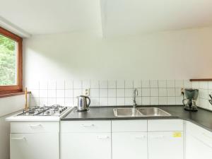 a white kitchen with a sink and a stove at Boutique Pet friendly Apartment in Bohon in Barvaux