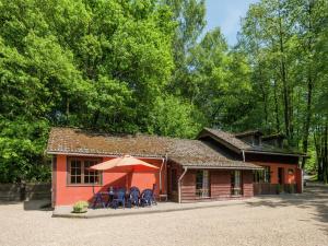 ウェームにあるModern Holiday Home in Waimes near Lakeの小さな赤い建物(椅子、傘付)