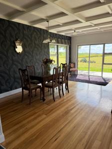 a dining room with a wooden table and chairs at The King's Rest in Matamata +13 photos