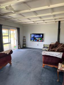 a living room with a couch and a flat screen tv at The King's Rest in Matamata