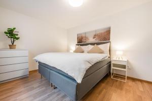 a bedroom with a blue bed and a dresser at SOHO A !Gratis parken, Free Parking! in Kreuzlingen