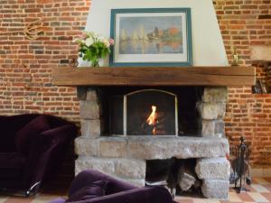 a brick fireplace with a fire in it at house listed as an historic building near Montreuil in Gouy-Saint-André
