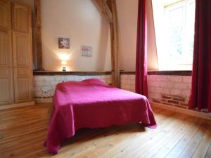 a bedroom with a bed with a pink blanket at house listed as an historic building near Montreuil in Gouy-Saint-André