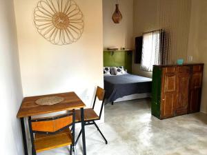 a room with a table and a bedroom with a bed at Casa Esmeralda in Lençóis
