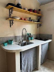 a kitchen counter with a sink and some shelves at Casa Esmeralda in Lençóis