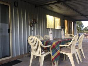 a table with white chairs and a colorful table cloth at York - Mulyinjinin Valley Cottage in York