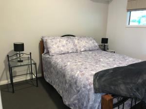 a bedroom with a bed and a table with two lamps at York - Mulyinjinin Valley Cottage in York