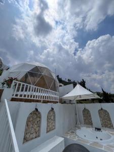 a white building with a balcony and an umbrella at Naima 2 in Panjadakan