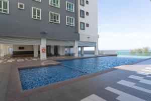 a swimming pool in front of a building at KT Seaview City Suite in Kuala Terengganu