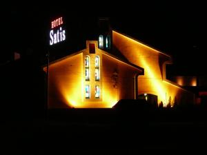 a building lit up at night with a neon sign at ホテルサティス伊勢店 in Ise