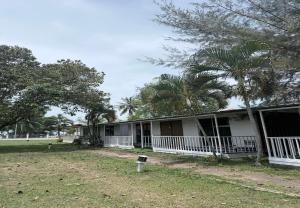 a white house with palm trees in front of it at Hotel Green Town Port Dickson in Port Dickson