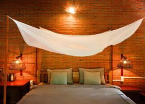 a bedroom with a bed with a net above it at Le Mékong Vert Ecolodge in Ben Tre