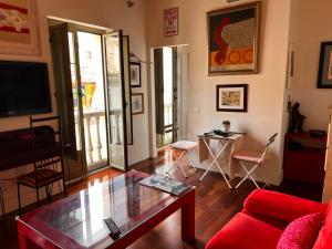 a living room with a red couch and a glass table at Beautiful Apartment Teatro Cervantes in Málaga