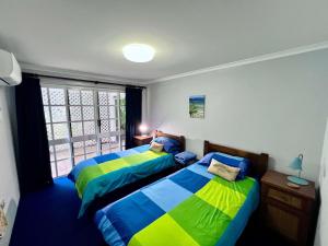 a bedroom with two beds and a window at Flying Fish House in South Mission Beach +27 photos
