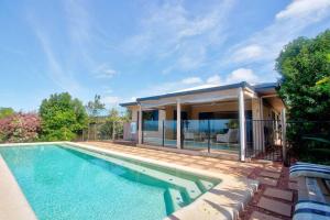 a swimming pool in front of a house at Le Reve Wake up to sunrises and tropical breezes in Mission Beach