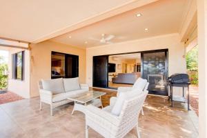 a living room with white chairs and a table at Le Reve Wake up to sunrises and tropical breezes in Mission Beach