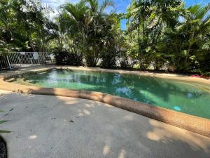 a large swimming pool in a yard with trees at Liana 4 Beach Lovers All at your finger tips in Mission Beach +6 photos