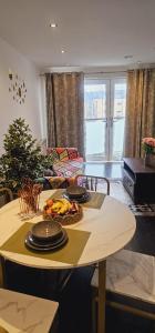 a kitchen with a table with plates and fruit on it at Excellent 2 bedroom Apartment- great Connectivity to central london in Barking +2 photos