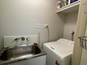 a small kitchen with a sink and a refrigerator at Liana 4 Beach Lovers All at your finger tips in Mission Beach
