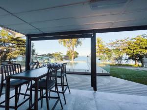 a dining table and chairs on a porch with a view of the water at Bella Luna Beach Front 2 bed in South Mission Beach