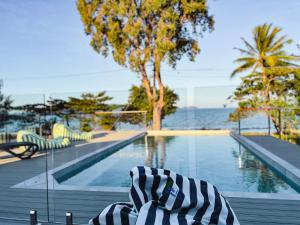 a person laying on a bench next to a swimming pool at Bella Luna Beach Front 2 bed in South Mission Beach