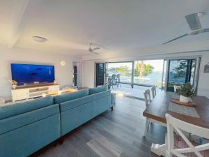 a living room with a blue couch and a tv at Bella Luna Beach Front 2 bed in South Mission Beach +30 photos