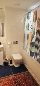 a bathroom with a toilet and a shower curtain at Excellent 2 bedroom Apartment- great Connectivity to central london in Barking