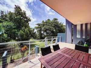 a deck with a wooden table and chairs on a balcony at BHA 4 Beachfront Bliss 2 bed in Mission Beach +32 photos