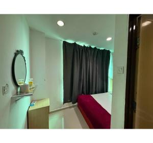 a small bedroom with a bed and a mirror at OYO 91288 Hotel PARADISE BATU CAVES in Batu Caves