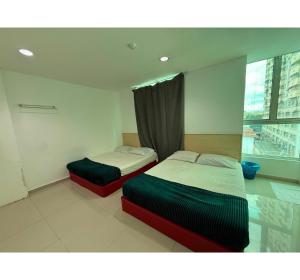 two beds in a room with a window at OYO 91288 Hotel PARADISE BATU CAVES in Batu Caves +29 photos