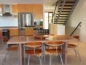 a kitchen with a wooden table and chairs at BHA 1 Beachfront Haven fullhouse in Mission Beach