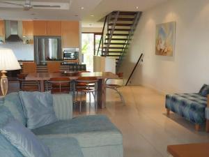 a living room with a couch and a table with chairs at BHA 1 Beachfront Haven fullhouse in Mission Beach