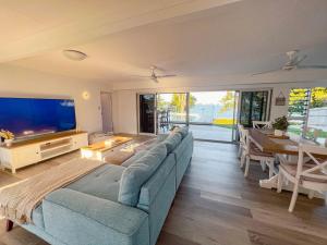a living room with a blue couch and a television at Bella Luna Beach Front Full house in South Mission Beach