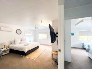 a bedroom with a bed and a tv in it at Bella Luna Beach Front Full house in South Mission Beach +39 photos
