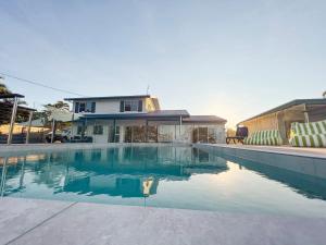 a swimming pool in front of a house at Bella Luna Beach Front Full house in South Mission Beach